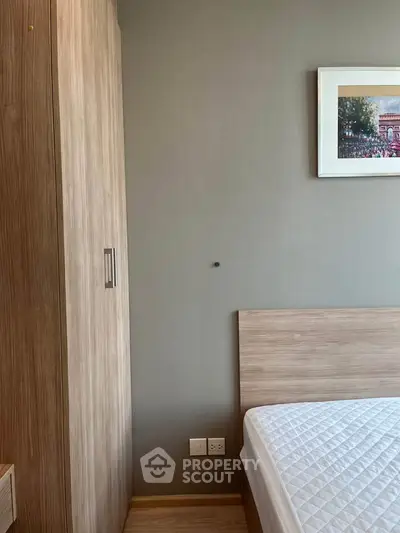 Modern bedroom with wooden wardrobe and framed artwork on wall