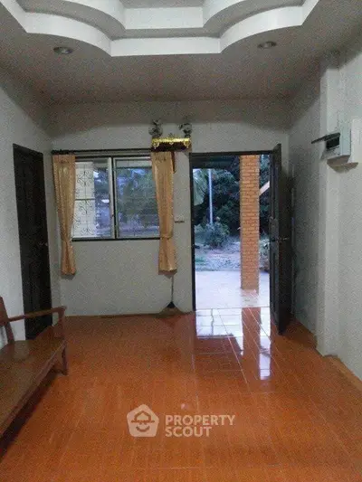 Spacious living room with tiled floor and open view to garden area.