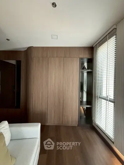 Modern living room with wooden paneling and large window blinds