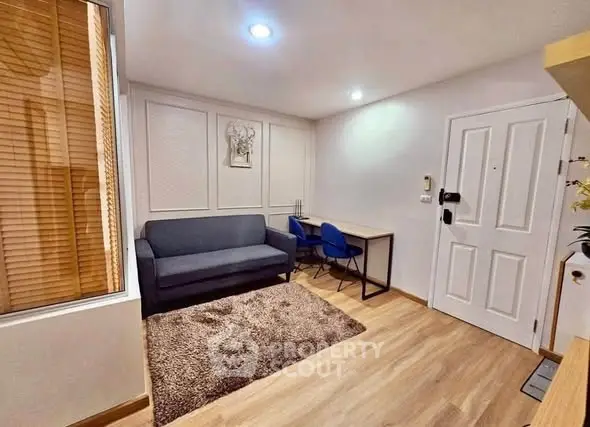 Modern living room with cozy sofa, study desk, and stylish decor in a bright apartment.