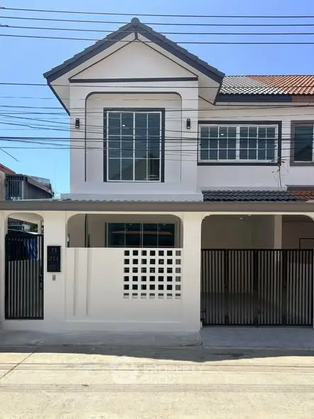 Charming two-story townhouse with modern facade and gated entrance in a serene neighborhood.