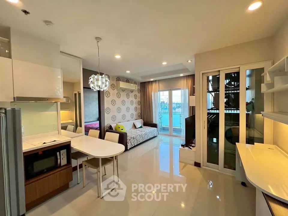 Modern open-plan studio apartment with stylish decor and balcony view.