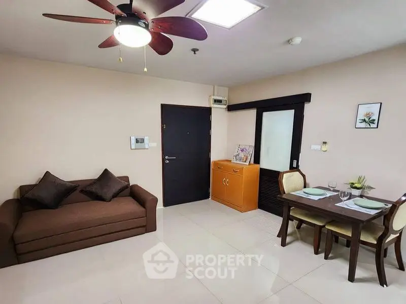 Cozy living room with dining area, modern ceiling fan, and stylish decor in a contemporary apartment.
