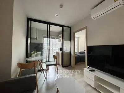 Modern apartment interior with open layout, featuring a cozy living area, dining space, and a glimpse of the bedroom.