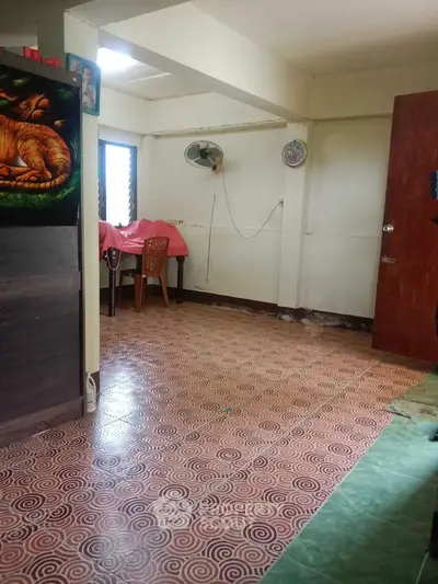 Cozy interior room with tiled flooring and simple furnishings, ideal for a compact living space.