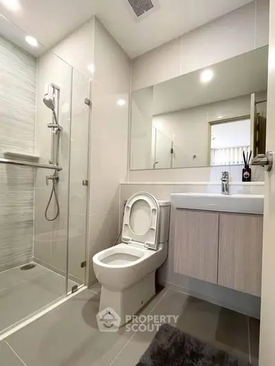 Modern bathroom with glass shower and sleek fixtures in a contemporary apartment.