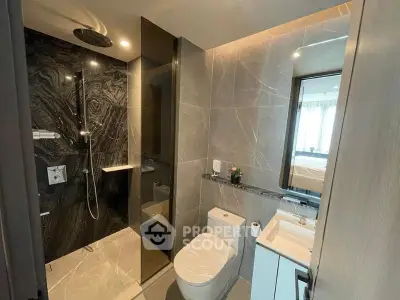 Modern bathroom with sleek design and luxurious shower in upscale apartment.