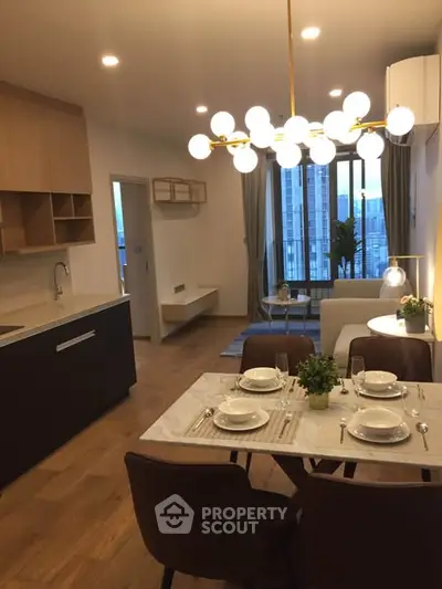 Modern open-layout kitchen and living room with elegant dining setup and city view.