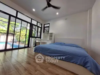 Spacious bedroom with pool view and modern furnishings