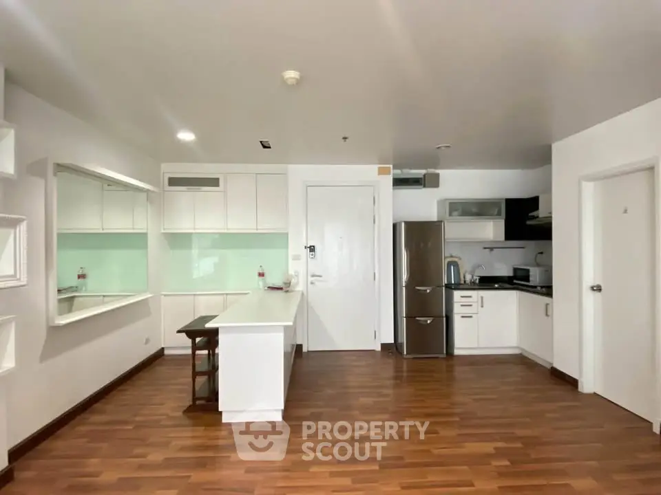 Modern kitchen with sleek white cabinets and stainless steel appliances in open layout.