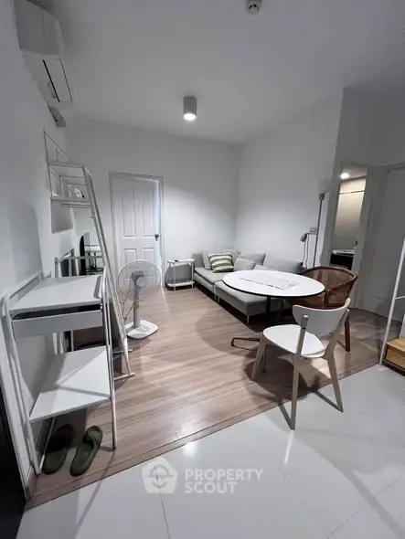 Modern living room with minimalist furniture and sleek wooden flooring.