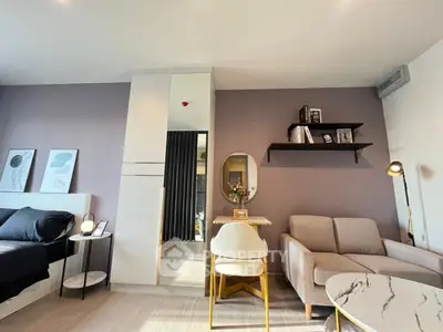 Modern studio apartment with stylish decor, featuring a cozy sofa, chic wall art, and a compact dining area.