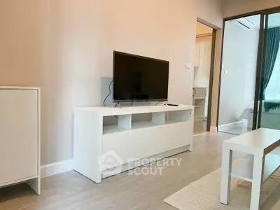 Modern living room with sleek white furniture and flat-screen TV, perfect for cozy relaxation.
