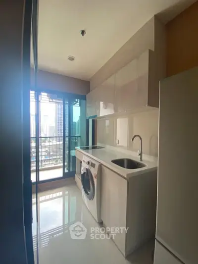 Modern kitchen with washing machine and city view from balcony