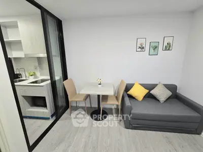 Modern compact living room with cozy sofa and dining area adjacent to sleek kitchen.