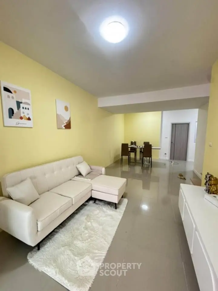 Spacious living room with modern decor and dining area in open layout apartment.