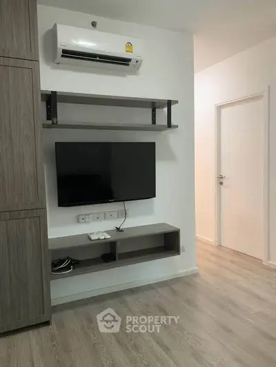 Modern living room with wall-mounted TV and air conditioning in a stylish apartment.