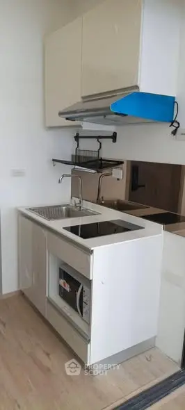 Compact modern kitchen with sleek cabinetry and built-in appliances, perfect for urban living.