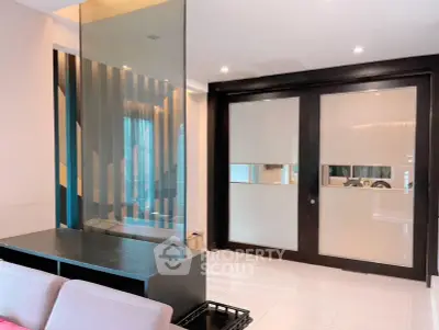 Modern living room with sleek glass partition and sliding doors, perfect for stylish urban living.