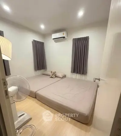 Cozy bedroom with air conditioning and minimalist decor, perfect for relaxation.