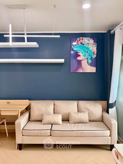 Modern living room with stylish sofa and contemporary wall art, featuring elegant lighting and chic decor.