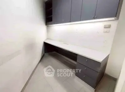 Spacious home office with built-in cabinets and ample workspace