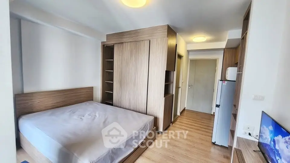Modern bedroom with wooden furniture and compact design in a cozy apartment.