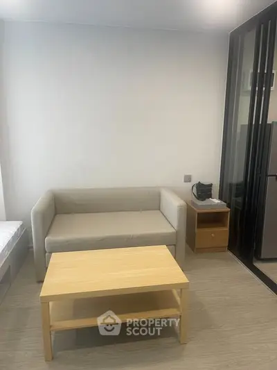 Modern living room with beige sofa, wooden coffee table, and sleek flooring.