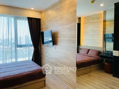 Modern bedroom with large window and wall-mounted TV in a stylish apartment.