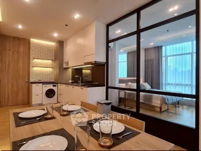 Modern open-plan kitchen and dining area with view into stylish bedroom