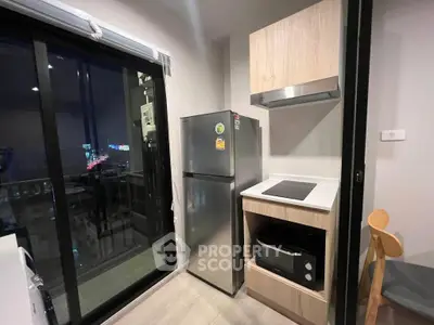 Modern kitchen with sleek appliances and balcony view in urban apartment