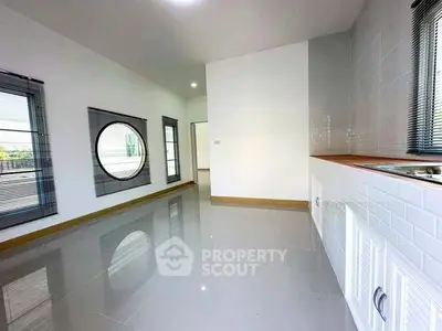 Spacious modern kitchen with sleek design and unique circular window feature.