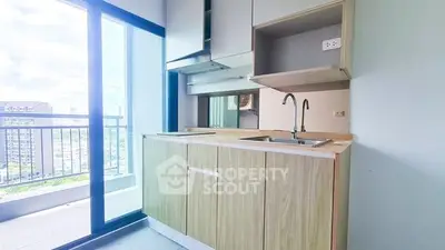 Modern kitchen with balcony view, sleek cabinetry, and ample natural light.