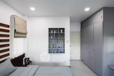 Modern bedroom with sleek built-in wardrobe and decorative shelving