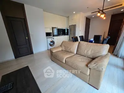 Spacious living room with modern kitchen and leather sofa in open layout apartment