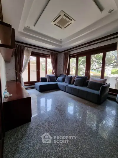 Spacious living room with large windows and modern sofa