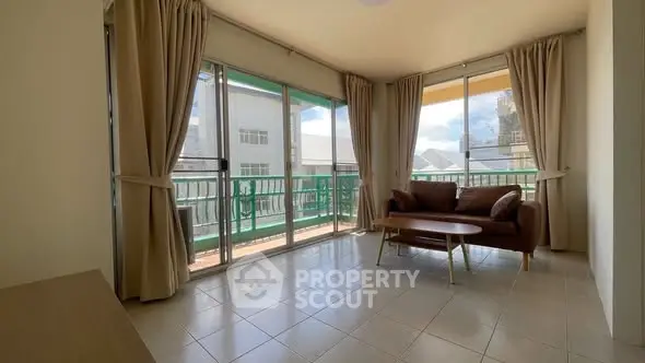 Spacious living room with large windows and balcony access