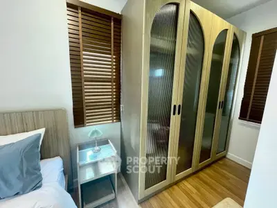 Cozy bedroom with stylish wardrobe and wooden blinds, perfect for modern living.