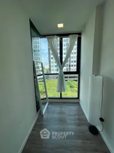 Bright room with large window and city view, featuring modern floor lamp and curtain decor.
