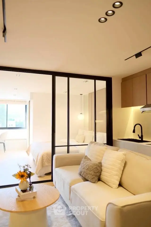 Modern studio apartment with open layout, featuring cozy living area and sleek kitchen design.