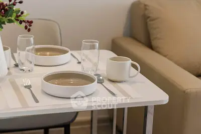 Modern dining setup with elegant tableware and cozy seating in a stylish living area.