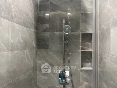 Modern bathroom shower with sleek gray tiles and built-in shelving