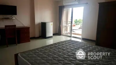 Spacious bedroom with glossy tiled flooring, large bed, and ample natural light streaming through the balcony doors, complemented by modern furnishings.