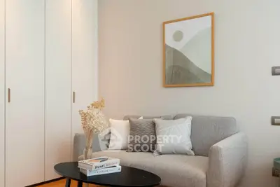 Cozy living room with modern decor, featuring a stylish sofa, elegant wall art, and a sleek coffee table.
