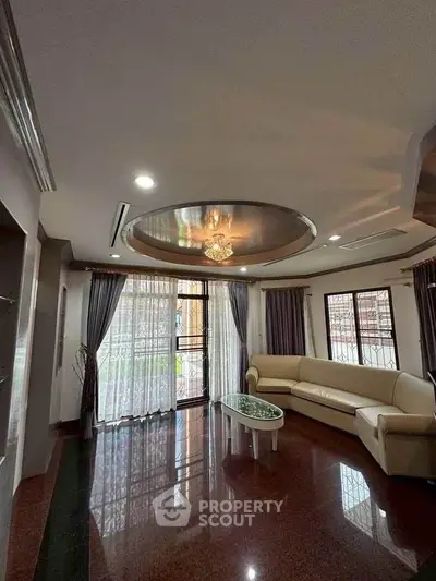 Elegant living room with luxurious ceiling design and large windows.