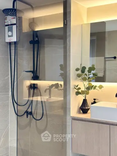 Modern bathroom with sleek shower design and elegant vanity mirror lighting.