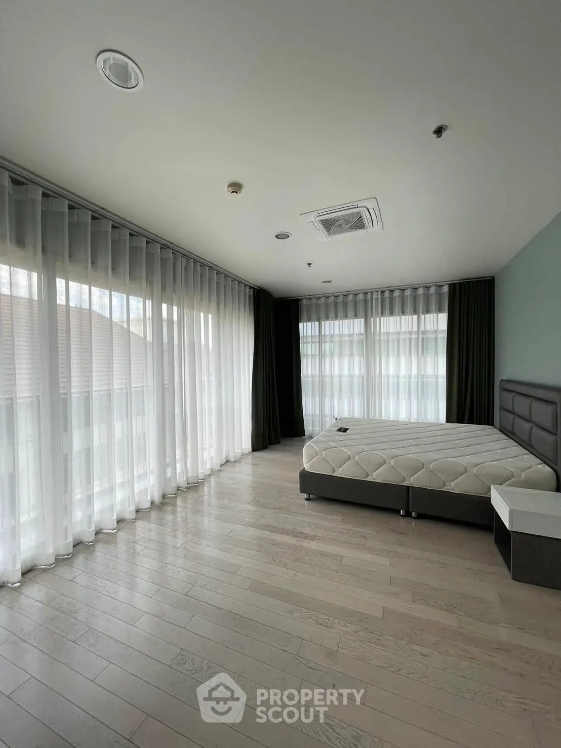 Spacious bedroom with large windows and modern decor