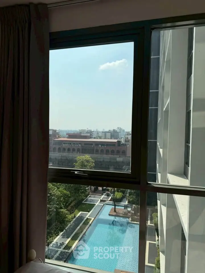 Stunning city view from high-rise apartment window overlooking pool and skyline.