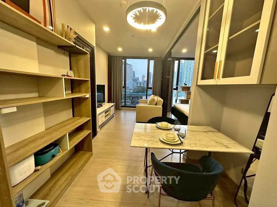 Modern living room with open layout and city view, featuring stylish furniture and elegant lighting.