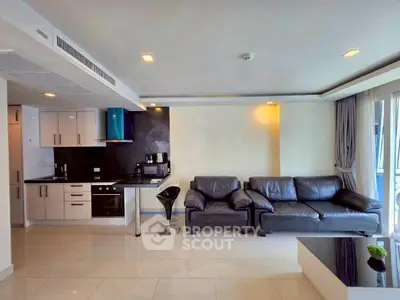 Modern living room with sleek kitchen, leather sofa, and natural light